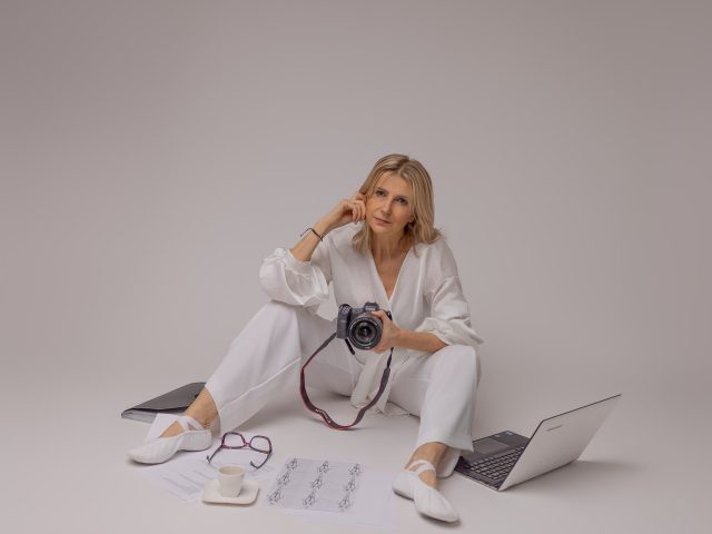 kobieta na białym tle w białym ubraniu trzyma aparat